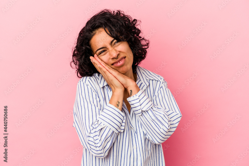 Young curly latin woman isolated on pink background yawning showing a tired gesture covering mouth with hand. Young curly latin woman isolated on pink background yawning showing a tired gesture covering mouth with hand.