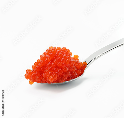 fresh grained red chum salmon caviar in metallic spoon, white background