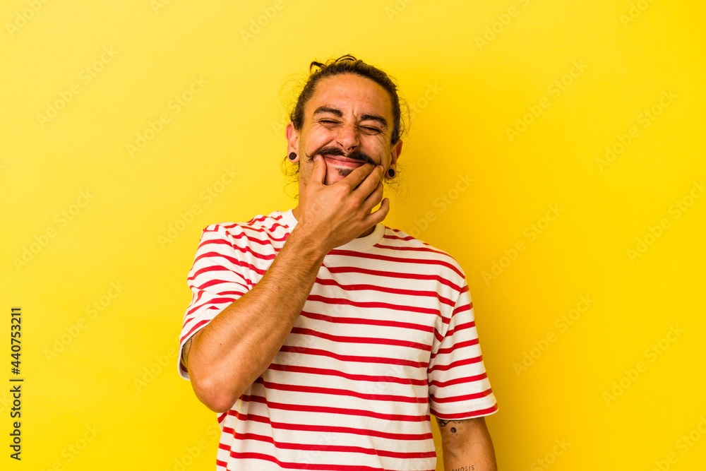 Young caucasian man with long hair isolated on yellow background doubting between two options. Young caucasian man with long hair isolated on yellow background doubting between two options.