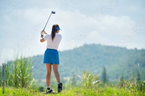 Female golf player hitting golf ball on fairway, Lifestyle woman playing game golf healthy and Sport outdoor in summer mountain hill.