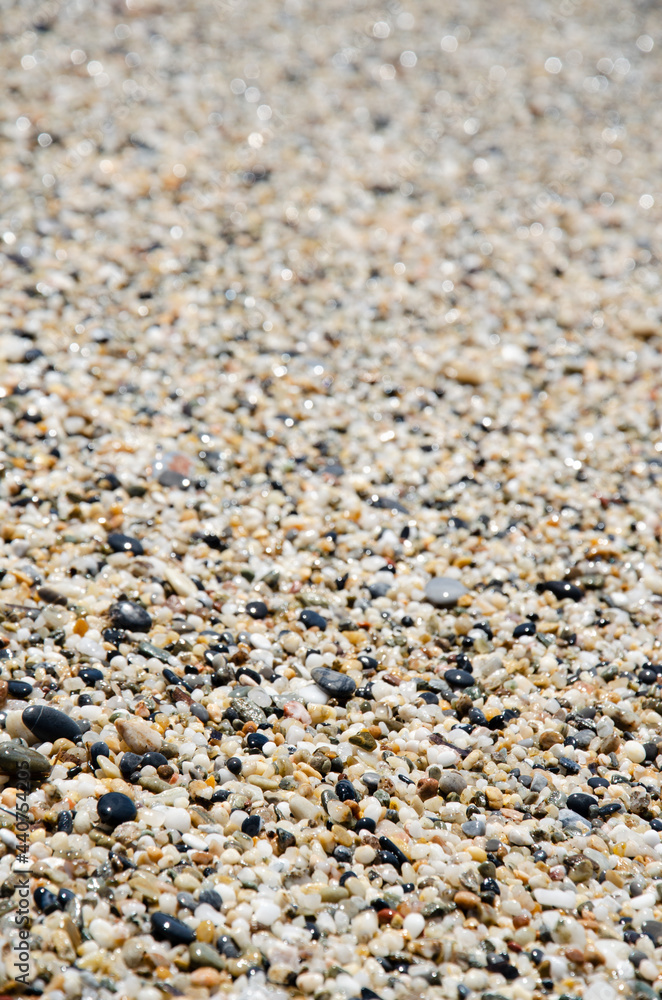Surface of the rocky beach. Pebble texture. Sea stones of various sizes cover the seaside. Selective focus multi-colored pebbles on the seashore. Natural background concept. Surface of the rocky beach. Pebble texture. Sea stones of various sizes cover the seaside. Selective focus multi-colored pebbles on the seashore. Natural background concept.