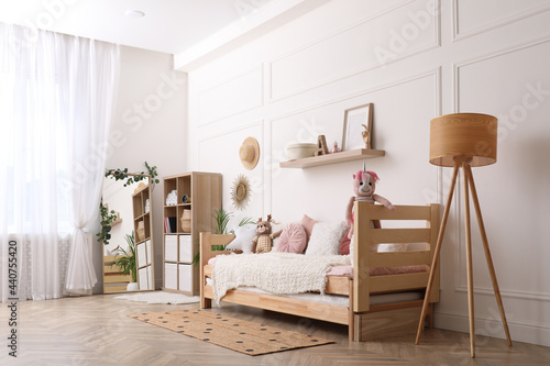 Cute child's room interior with comfortable bed and toys