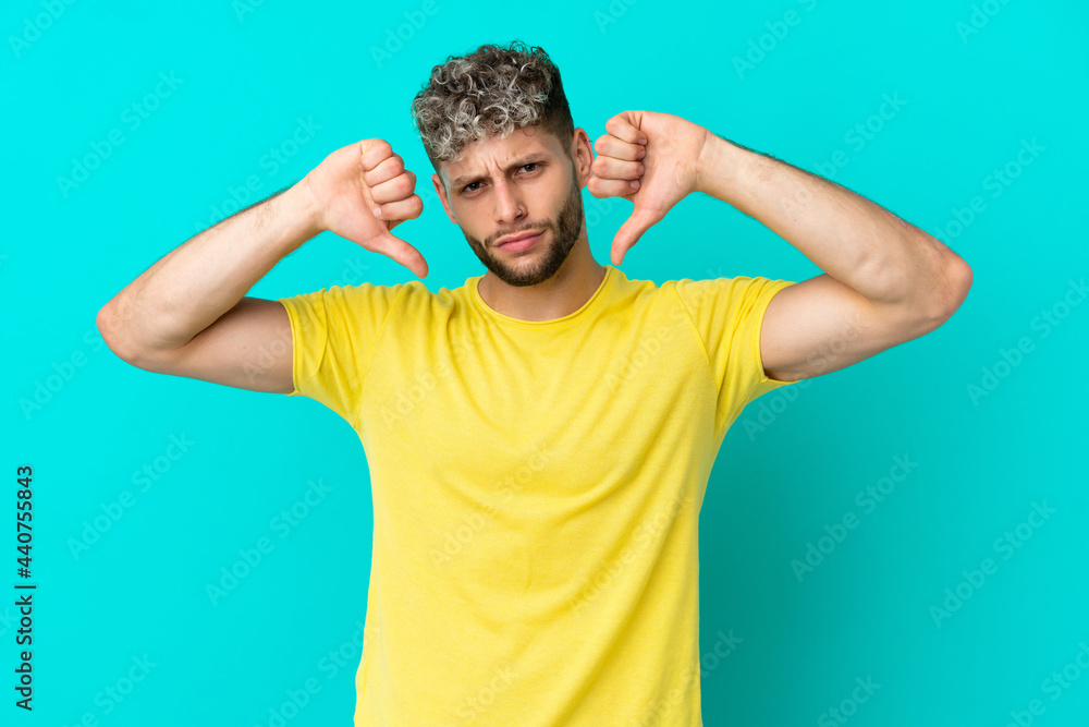 Fototapeta premium Young handsome caucasian man isolated on blue background proud and self-satisfied
