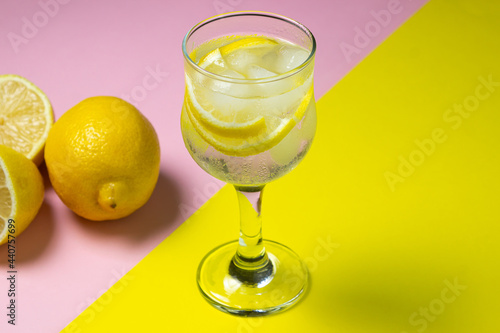 Refreshing cocktail with ice and lemon on a colored background. Non-alcoholic cocktail.