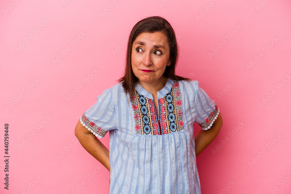 Middle age caucasian woman isolated on pink background confused, feels doubtful and unsure. Middle age caucasian woman isolated on pink background confused, feels doubtful and unsure.