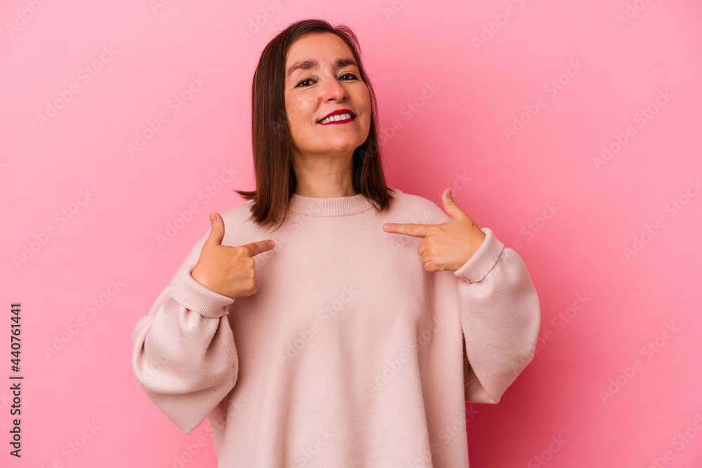 Middle age caucasian woman isolated on pink background person pointing by hand to a shirt copy space, proud and confident Middle age caucasian woman isolated on pink background person pointing by hand to a shirt copy space, proud and confident