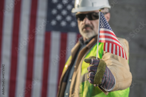 A serious worker man and american flag 