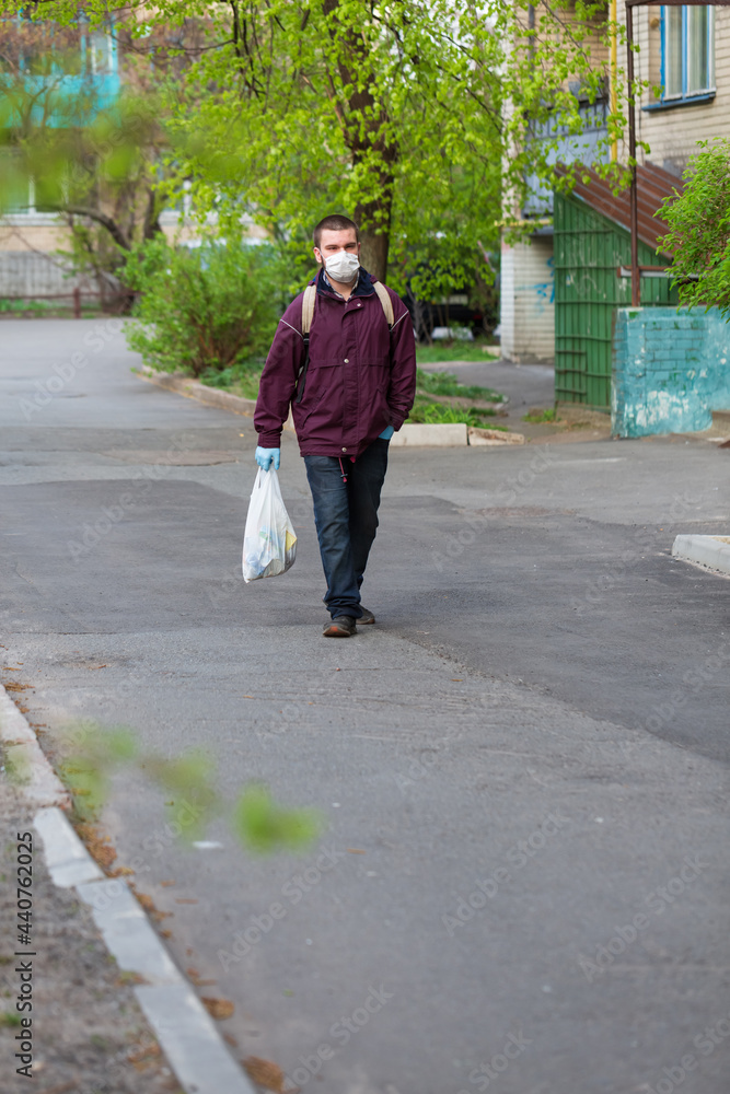 A guy in a protective mask and gloves on a city street during the Covid pandemic A guy in a protective mask and gloves on a city street during the Covid pandemic