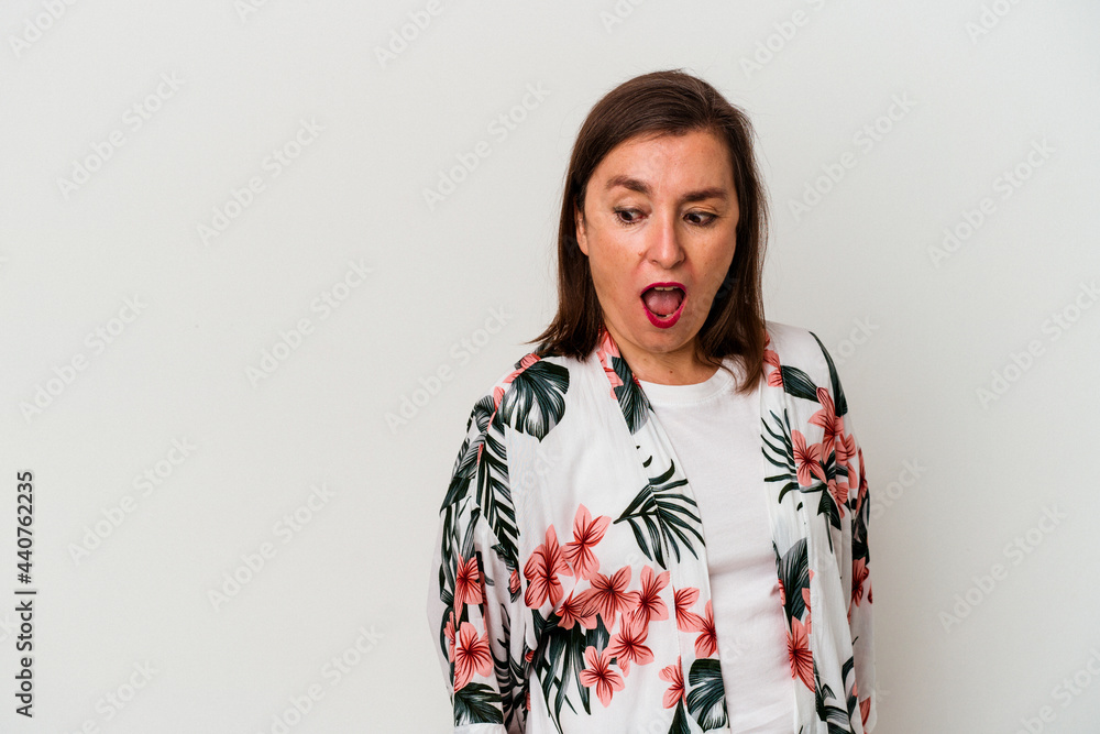 Middle age caucasian woman isolated on white background being shocked because of something she has seen. Middle age caucasian woman isolated on white background being shocked because of something she has seen.