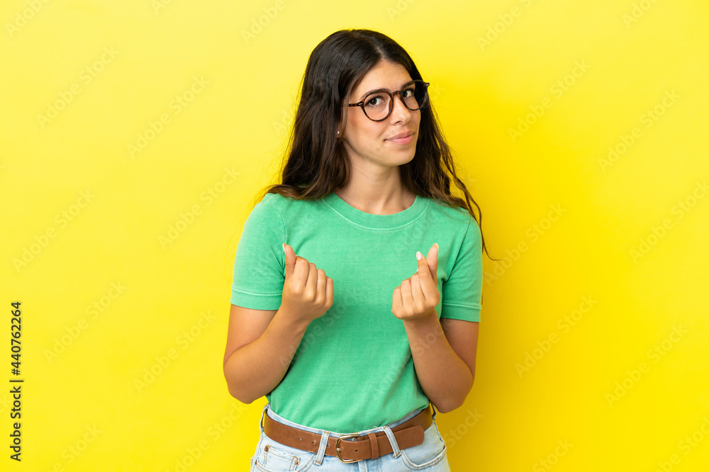 Young caucasian woman isolated on yellow background making money gesture but is ruined Young caucasian woman isolated on yellow background making money gesture but is ruined
