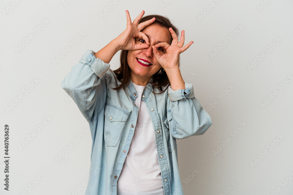 Middle age caucasian woman isolated on white background showing okay sign over eyes Middle age caucasian woman isolated on white background showing okay sign over eyes