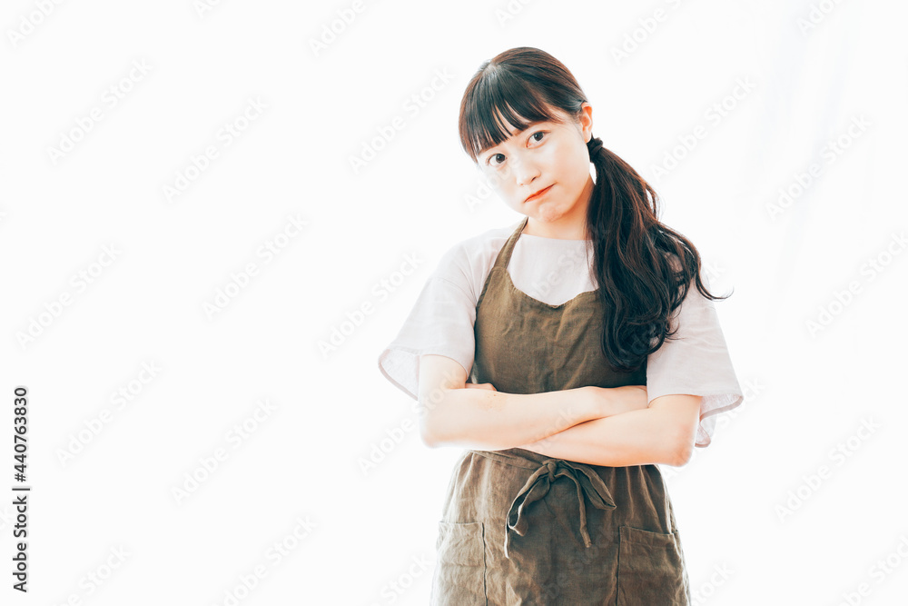 エプロンを着て悩む若い女性