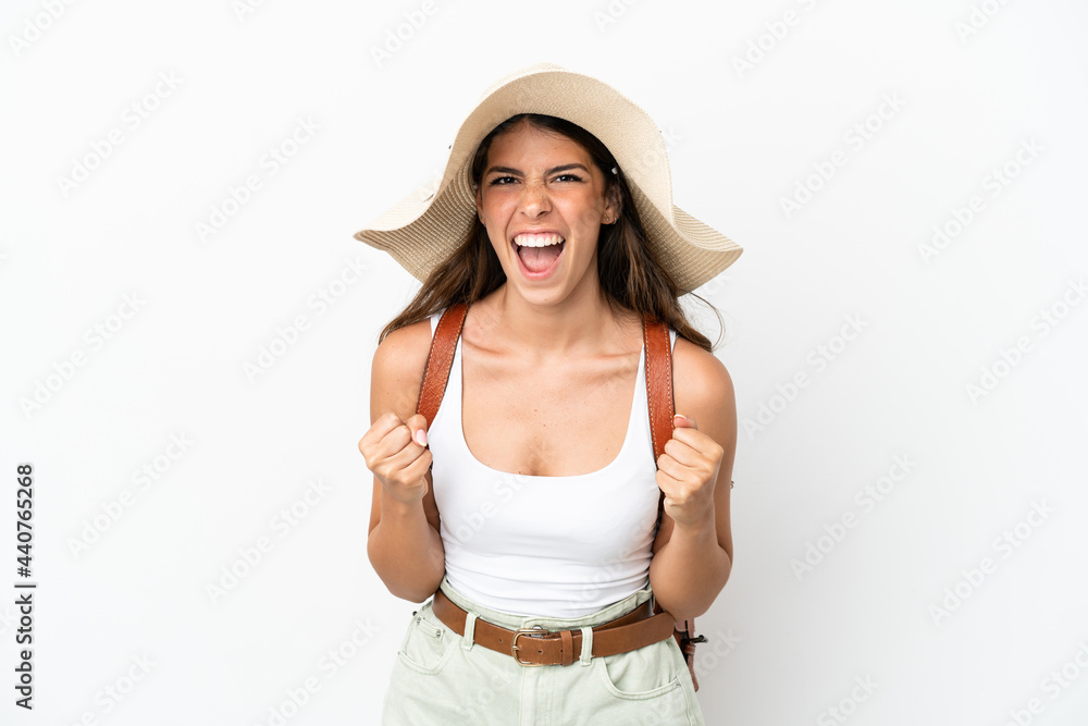 Young caucasian woman wearing a Pamela in summer holidays isolated on white background celebrating a victory in winner position Young caucasian woman wearing a Pamela in summer holidays isolated on white background celebrating a victory in winner position