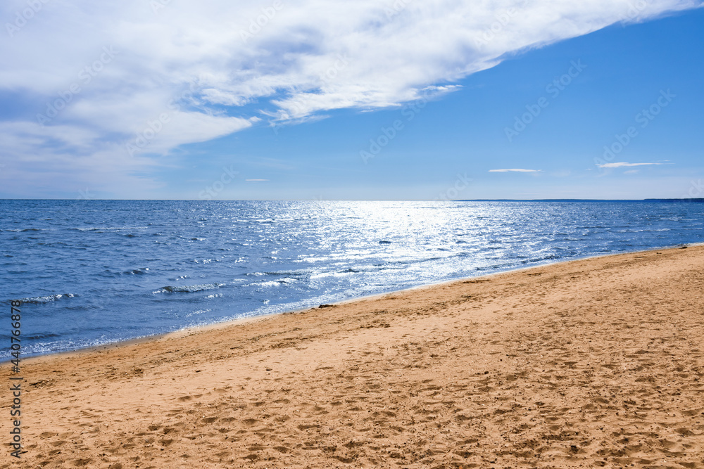 Sunny beach, blue sea under blue sky with white clouds, summer seascape.
