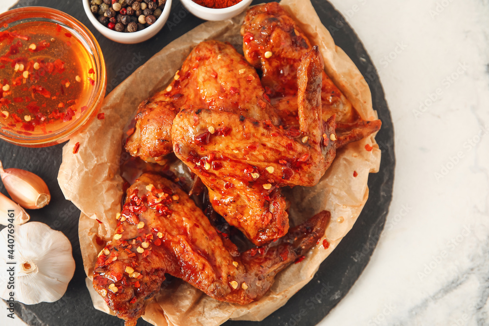 Board with tasty fried chicken wings, spices and hot honey on light background, closeup Board with tasty fried chicken wings, spices and hot honey on light background, closeup