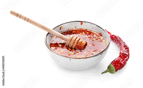 Bowl of hot honey and dry chili pepper on white background photo