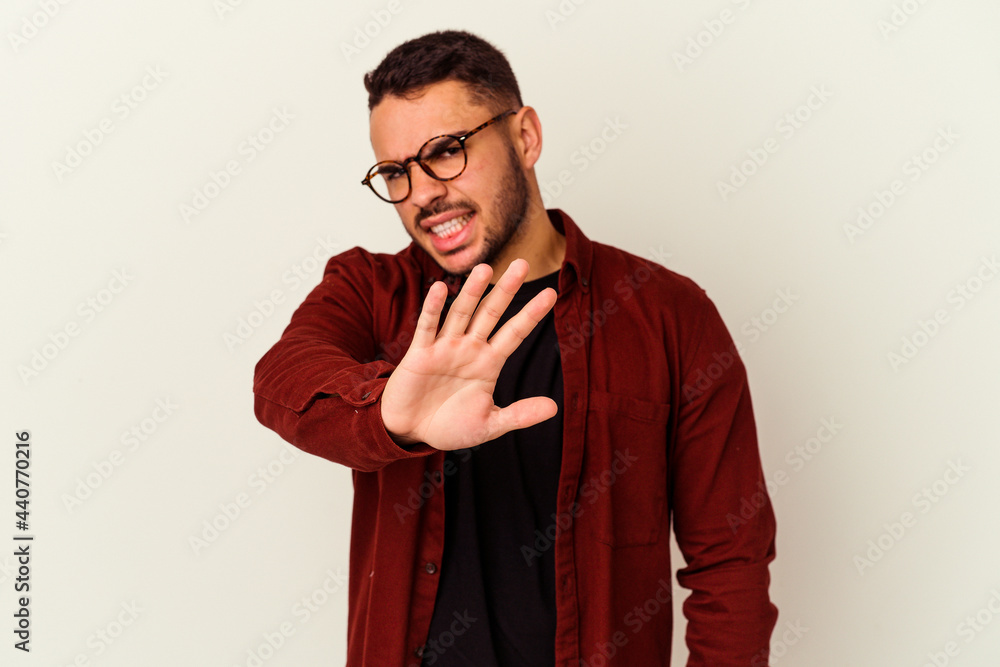 Young caucasian man isolated on white background rejecting someone showing a gesture of disgust.