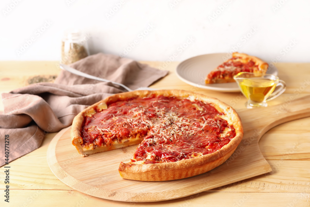 Board with tasty Chicago-style pizza on wooden table Board with tasty Chicago-style pizza on wooden table