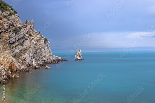 Dramatic sky over the rocky coast and the Parus rock on the Black Sea coast. Crimean Peninsula