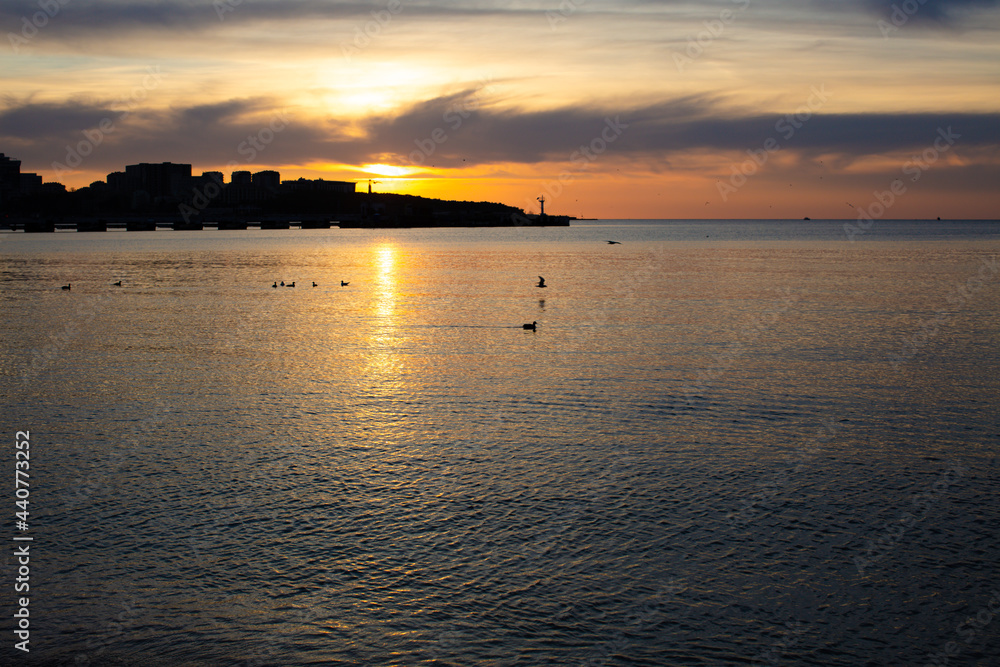 Naklejka premium City on the sea at sunset