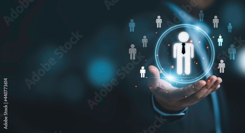 Businessman holding virtual infographic with human icons for human development and recruitment concept.