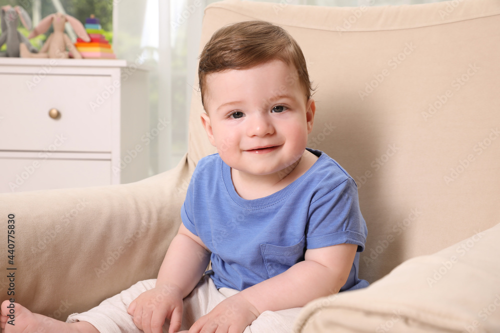 Happy baby boy sitting in armchair at home Happy baby boy sitting in armchair at home