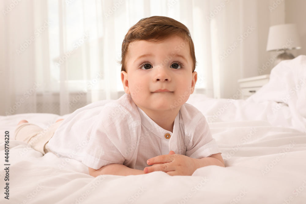 Cute baby boy on bed at home