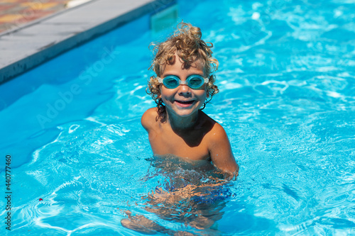 Curly boy in the pool with glasses