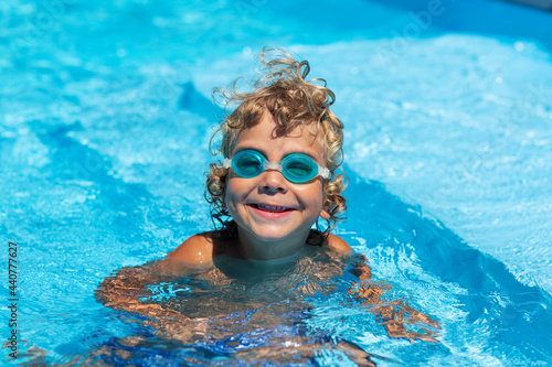 Curly boy in the pool with glasses