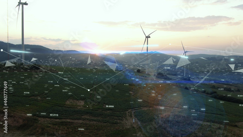 Windmill farm on beautiful summer sunset with graphics. Nano technology. Futuristic tech innovation. Ecology concept. Landscape.