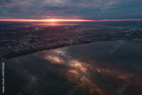 Aerial drone filmed sunset, burning sky over the city and water, beautiful sunset or sunrise. Panoramic view over the bridge with the sun