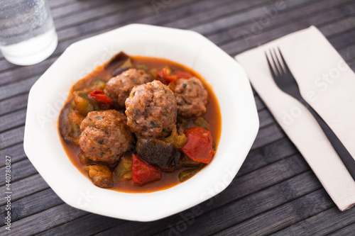 baked meatballs with stewed eggplant, zucchini, green peppers and tomatoes in bowl