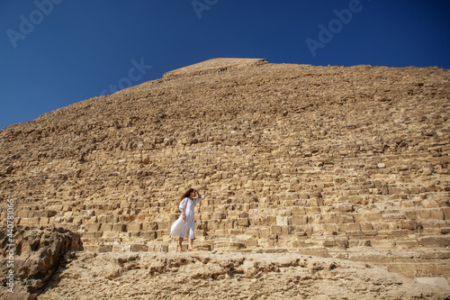 Beautiful woman near the ancient pyramids of Egypt