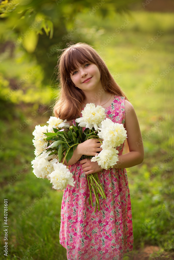 Photo of a young girl with a bouquet of white peonies. Photo of a young girl with a bouquet of white peonies.