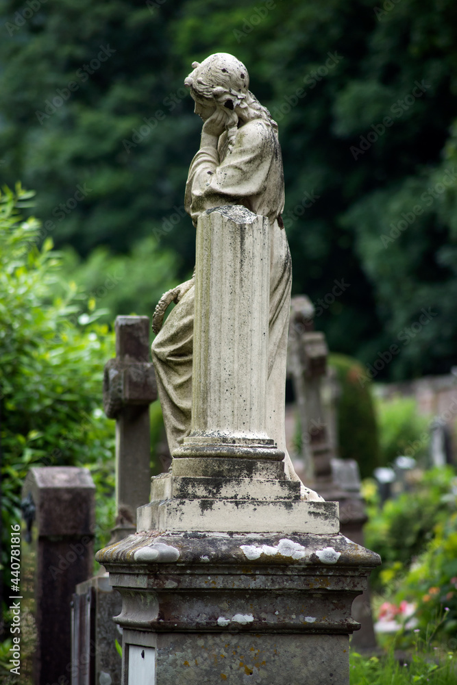View of the virgin mary statue on tomb in a cemetery