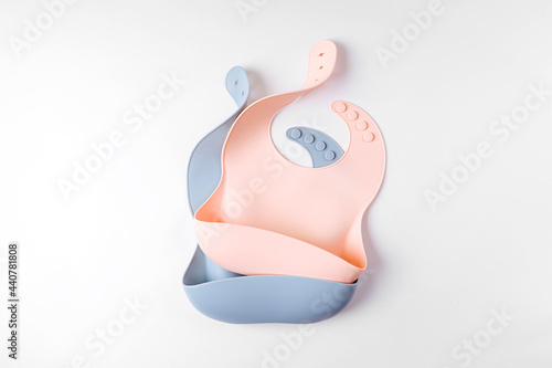 Pink and blue silicone baby bib isolated on white background photo