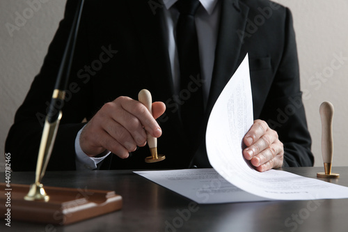 Konstfotografi Male notary stamping document at table, closeup