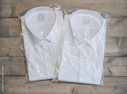 White shirt folding in the package on wooden background. photo