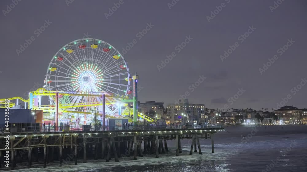 People having fun at the Ferris wheel at night by the pier at night People having fun at the Ferris wheel at night by the pier at night