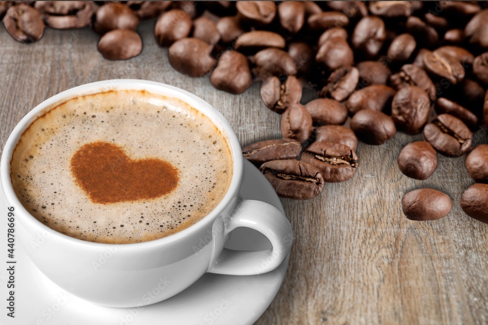 Cafes and restaurants. A mug of black coffee with foam in a heart shape and coffee beans. Cafes and restaurants. A mug of black coffee with foam in a heart shape and coffee beans.