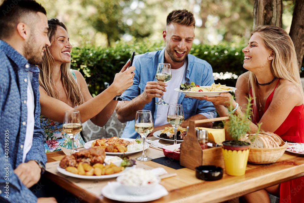 Group of Happy friends having lunch in the restaurant during a sunny summer day Group of Happy friends having lunch in the restaurant during a sunny summer day