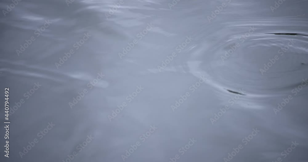 A slow motion of rain drop in the water the pond rainy day closeup A slow motion of rain drop in the water the pond rainy day closeup