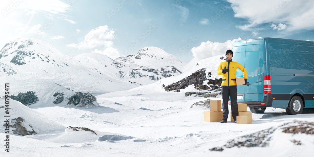 Deliveryman Holding Cardboard Box in Hand Standing At Van in the Middle of Snowy Mountains at Sunny Day.