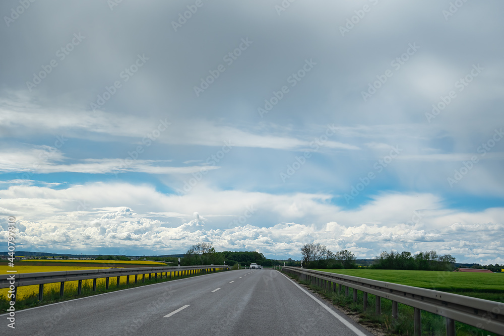 view of the road through the fields, on a summer sunny day in bavaria