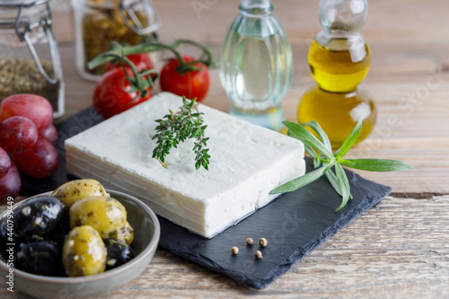 Greek feta cheese on a black plate. Greek authentic feta cheese with olives on the side.
