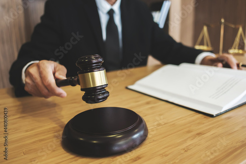 Lawyer preparing to sign a contract and wooden gavel on table justice and law concept.