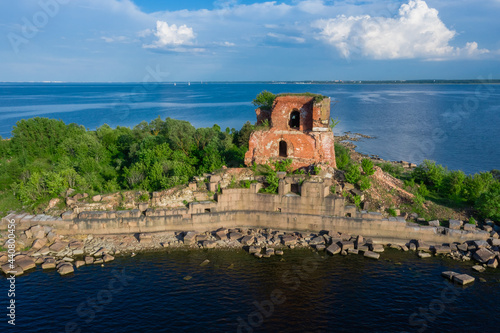 View from the height of the fort Emperor Paul 1 in Kronstadt, the Gulf of Finland, the island of forts, a ruined red brick building in the Gulf of Finland. photo