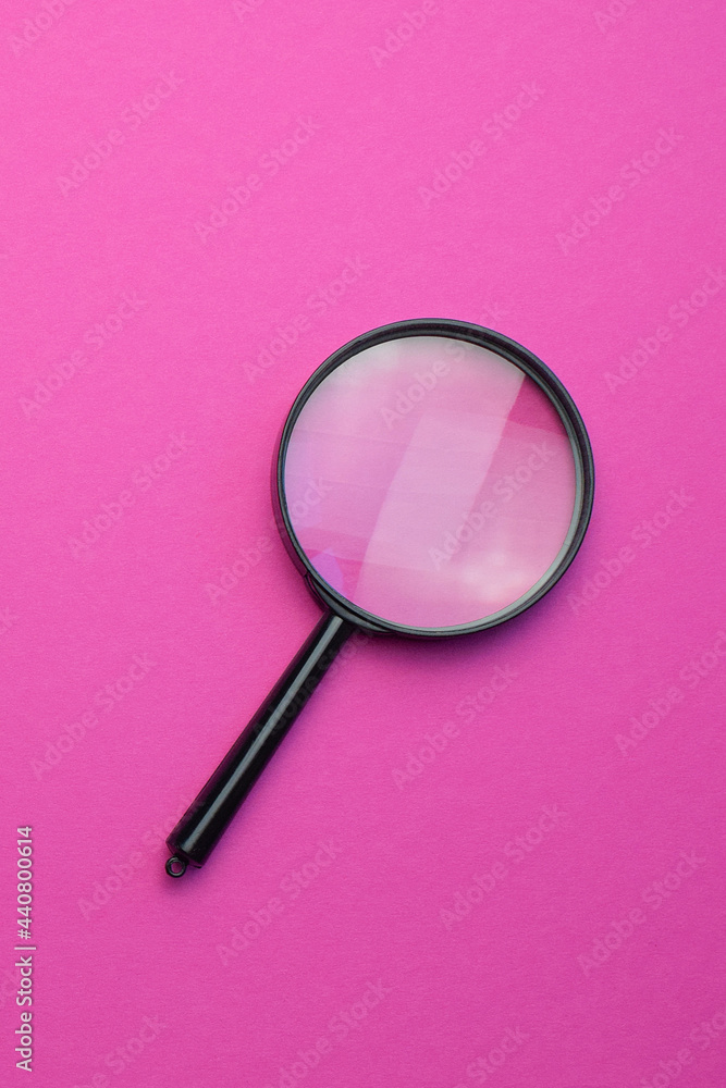 Magnifying glass on a colored background. Top view. Vertical photo. Copy space for text. Magnifying glass on a colored background. Top view. Vertical photo. Copy space for text.