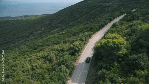 Aerial shot of a car driving on a mountain road
