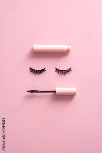 Fototapeta Naklejka Na Ścianę i Meble -  Creative flatlay composition with mascara and false eyelashes on pink background. Makeup cosmetics set.